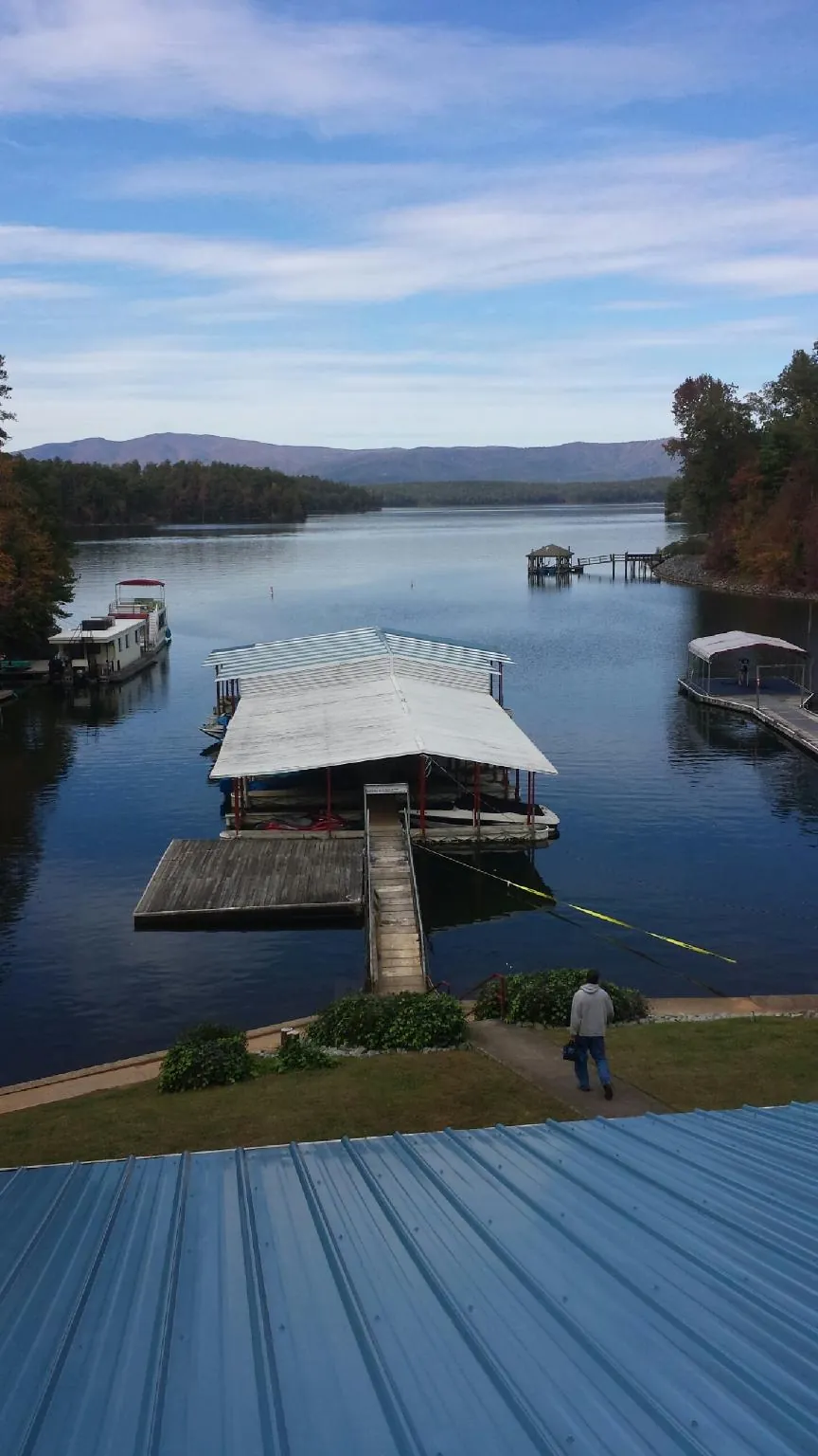 View across a lake from a newly installed blue metal roof in Bennett
